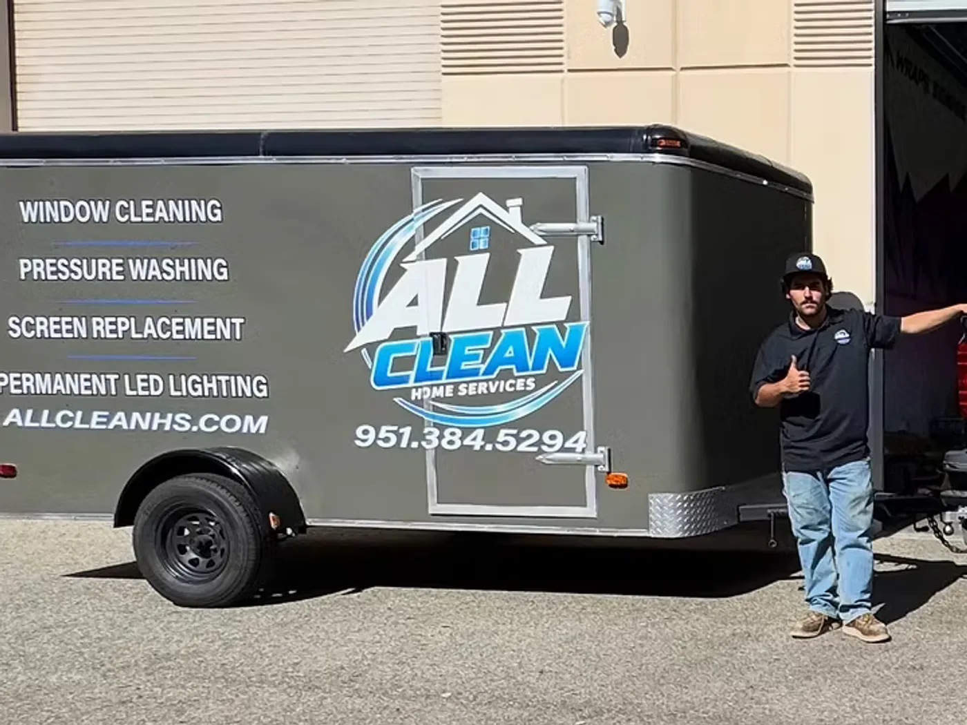ALLCLEAN Home Services crew member standing between the company trailer and truck
